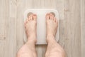 Male bare feet stand on smart scales that makes bioelectric impedance analysis, BIA, body fat measurement. Top view. Royalty Free Stock Photo