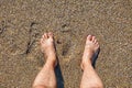 Male bare feet standing on wet sandy beach Royalty Free Stock Photo