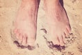 Male Bare Feet In A Warm Sand On A Sunny Beach During Vacation.