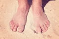 Male bare feet in a warm sand Royalty Free Stock Photo