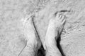 Male Bare Feet In A Warm Sand On A Sunny Beach During Vacation.