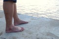 A male barefoot standing on hard cement pathway with dark river below Royalty Free Stock Photo