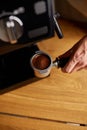 Male barista hand making espresso from ground coffee maker at modern cafe Royalty Free Stock Photo