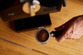 Male barista hand making espresso from ground coffee maker at modern cafe Royalty Free Stock Photo