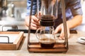 Male barista making pour-over coffee with alternative method called dripping. Close up modern coffee grinder, coffee stand. Royalty Free Stock Photo