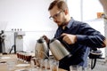 Barista brewing fresh coffee in cups