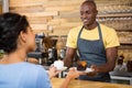 Male barista serving coffee and dessert to female customer Royalty Free Stock Photo