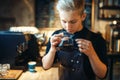 Male barista sniffs fresh prepared black coffee