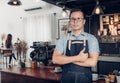 Male Barista thumbs up in front on cafe counter bar with customer sitting inside coffee shop,Good owner food and drink