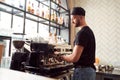 Male barista working on coffee machine