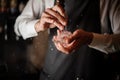 Male bartender breaking an ice cube with a special tool