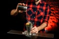 Male bartender is holding metal jar and pouring powder on glass Royalty Free Stock Photo