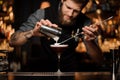 Male bartender makes cocktail using shaker and spoon Royalty Free Stock Photo