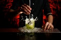 Male bartender making alcoholic cocktail in glass which splashing out Royalty Free Stock Photo