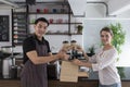 Male bartender serving passing hot drinks to female customer at coffee shop. Royalty Free Stock Photo