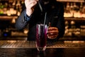 Male Bartender makes alcohol cocktail with dropper Royalty Free Stock Photo