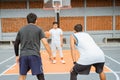 a male basketball player carrying the ball is blocked by two opposing players in a ready position Royalty Free Stock Photo