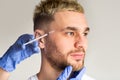 Male beauty care concept. Doctor makes man beauty injection