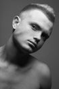 Male beauty concept. Portrait of fashionable and undressed young man with stylish haircut posing over gray background. Perfect Royalty Free Stock Photo