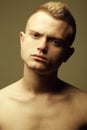 Male beauty concept. Portrait of fashionable and undressed young man with stylish haircut posing over mustard background. Perfect