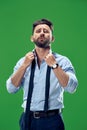 Male beauty concept. Portrait of a fashionable young man with stylish haircut wearing trendy suit posing over green Royalty Free Stock Photo