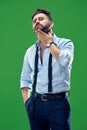 Male beauty concept. Portrait of a fashionable young man with stylish haircut wearing trendy suit posing over red Royalty Free Stock Photo