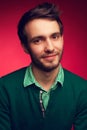 Male beauty concept. Portrait of a smiling elegant young & handsome man in green sweater posing over pink background. Perfect skin Royalty Free Stock Photo