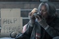 Homeless man on the stair of the walkway street in the city eating bread and milk form kindness people give him Royalty Free Stock Photo