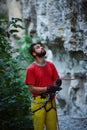 Male belayer with the rope under the cliff