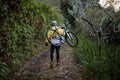 Male biker carrying mountain bike and walking on dirt track Royalty Free Stock Photo