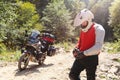 Male biker, motorcyclist in a white helmet. Stands next to a long-distance touring motorcycle. Side bags and luggage. mountain Royalty Free Stock Photo