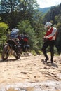 Male biker, motorcyclist in a white helmet. Stands next to a long-distance touring motorcycle. Side bags and luggage. mountain Royalty Free Stock Photo