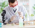 Male biochemist working in the lab on plants