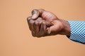 Male black fist on brown background. African american clenched hand, gesturing up Royalty Free Stock Photo