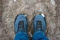 Male blue jeans and boots standing in mud and snow covered pathway top view close up shot