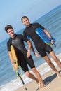 2 male bodyboarders getting out ocean Royalty Free Stock Photo