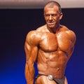 Male bodybuilder flexes his muscles and shows his best physique