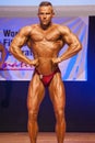 Male bodybuilder flexes his muscles to show his physique