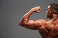 Male bodybuilder flexing bicep, back view with copy space Royalty Free Stock Photo