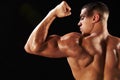 Male bodybuilder flexing bicep, back view with copy space Royalty Free Stock Photo