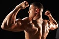 Male bodybuilder flexing muscles, side view Royalty Free Stock Photo