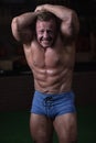 Male bodybuilder posing in the gym. Male athlete shows off his figure