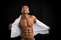 Male bodybuilder taking off his shirt revealing muscular torso Royalty Free Stock Photo