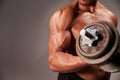 Male bodybuilder working out with a heavy dumbbell, crop detail Royalty Free Stock Photo