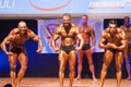 Male bodybuilders flexing muscles at championship on stage