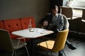 Male in bowl chair working on laptop with water glass