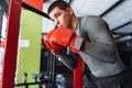 Male boxer engaged in training in the gym, in a cage for a fight