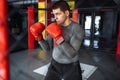 Male boxer engaged in training in the gym, in a cage for a fight