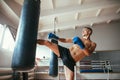 Male boxer workout high kick on the punching bag in gym Royalty Free Stock Photo