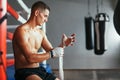 Male boxer is wrapping hands with boxing wraps